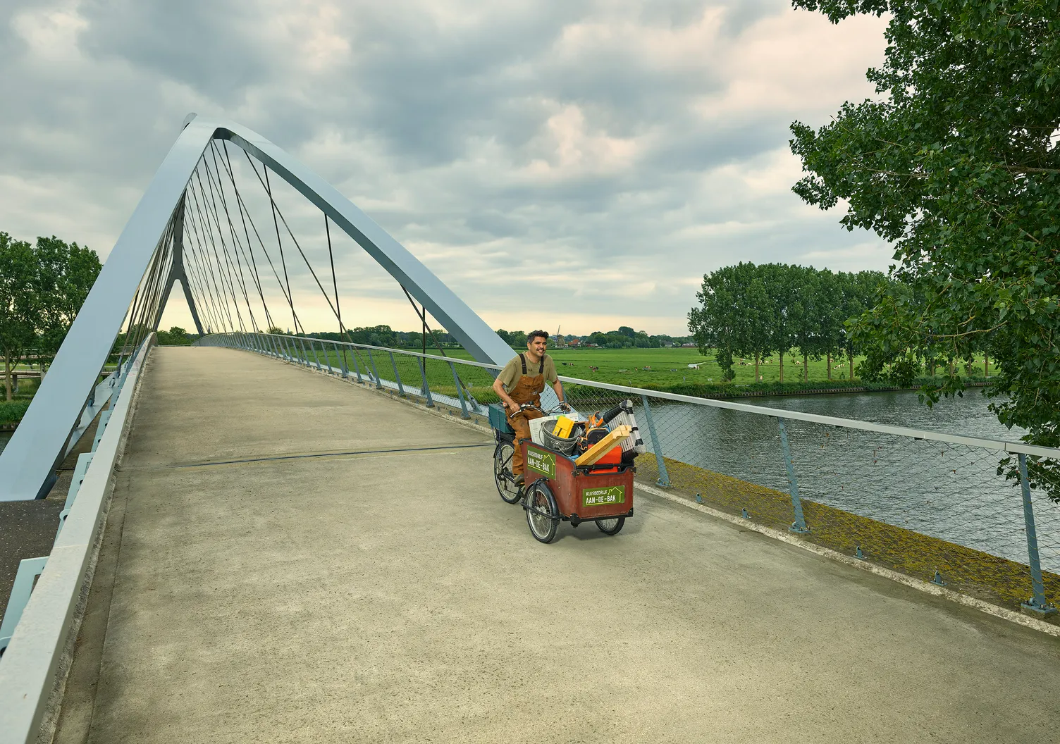 Man op een bakfiets met kinderen in de bak.