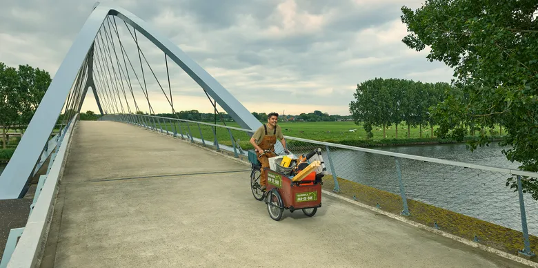 Man op een bakfiets met kinderen in de bak.