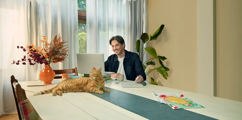 Man die aan het thuiswerken is met een kat.