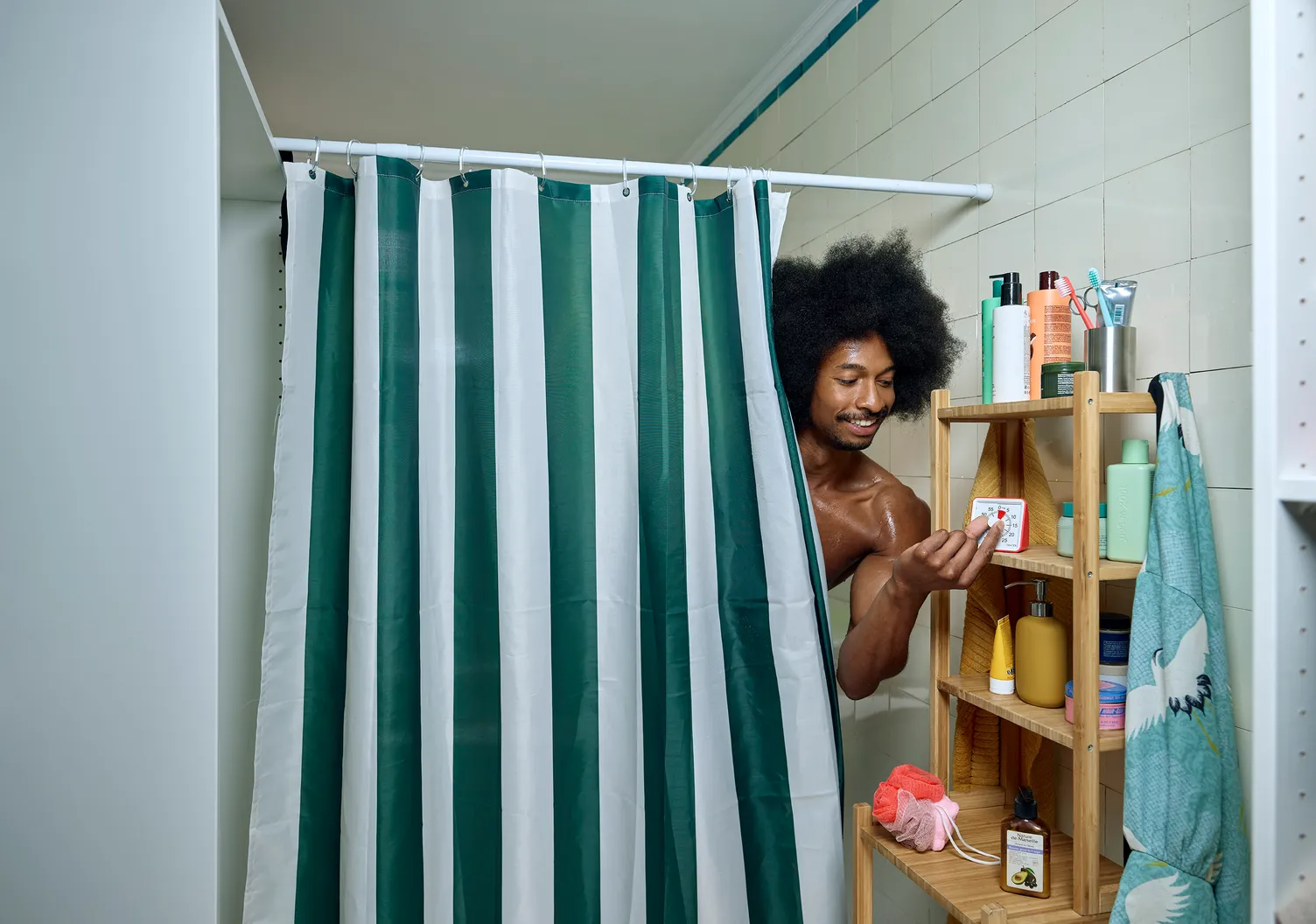 Een man onder de douche die een timer aanzet.
