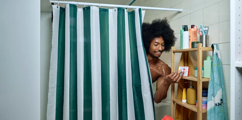 Een man onder de douche die een timer aanzet.
